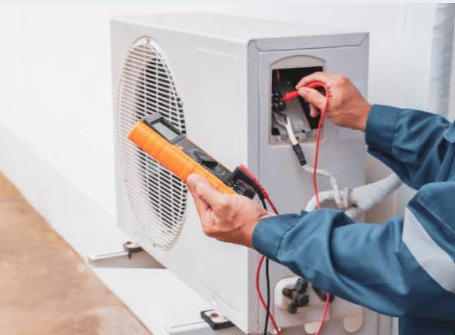 Technician testing electrical components on a residential air conditioner